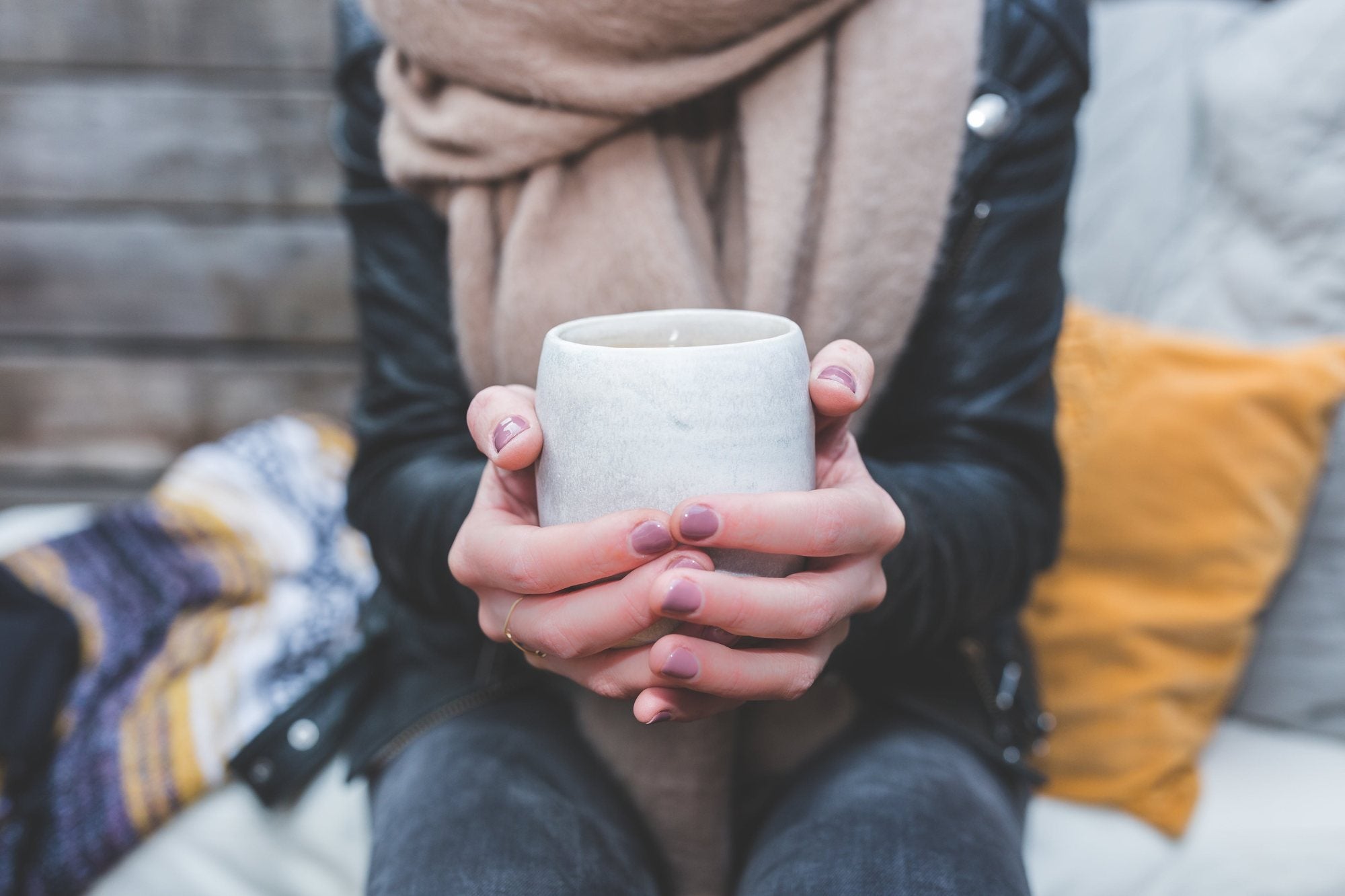 Two hands wrapped around a warm mug of coffee