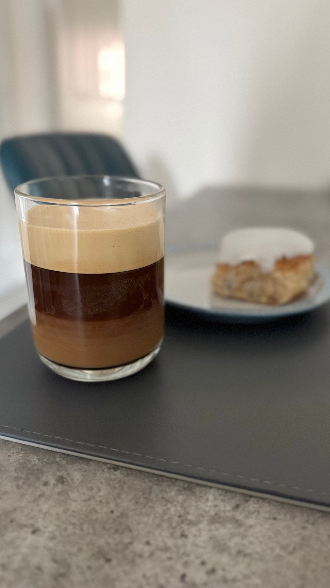 A layered coffee in a glass on a kitchen worktop