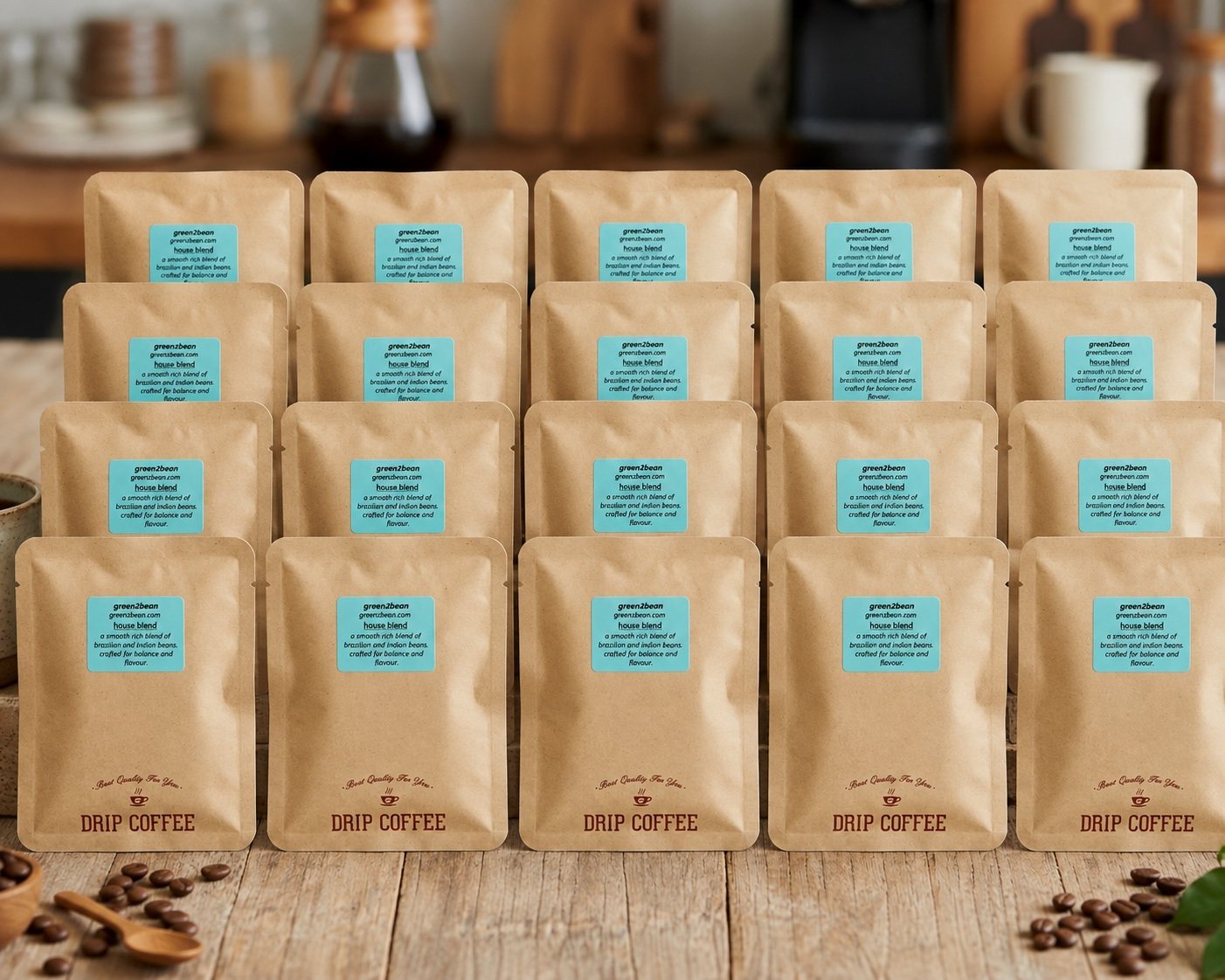 Twenty individually sealed Green2bean drip coffee pouches laid out in rows on a wooden table